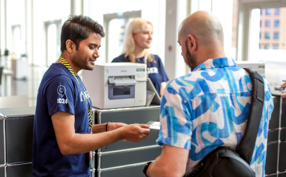 supportteam Support team members helping an attendee at the ticket desk